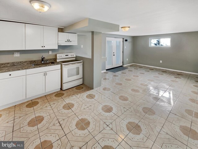 kitchen featuring white cabinets, white range with electric stovetop, dark stone countertops, and sink