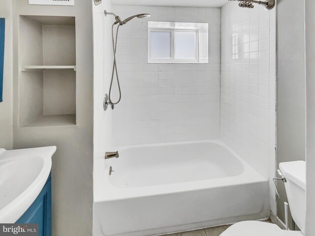 full bathroom featuring tile patterned flooring, tiled shower / bath combo, toilet, and vanity