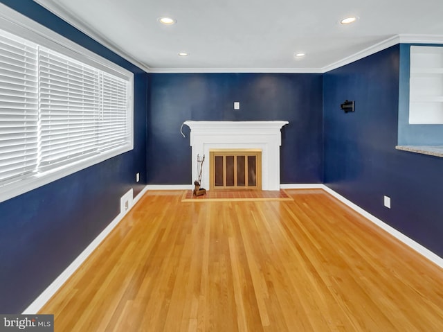 unfurnished living room with hardwood / wood-style floors and ornamental molding