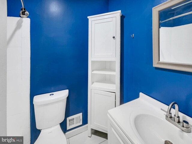 bathroom with a shower, vanity, and toilet