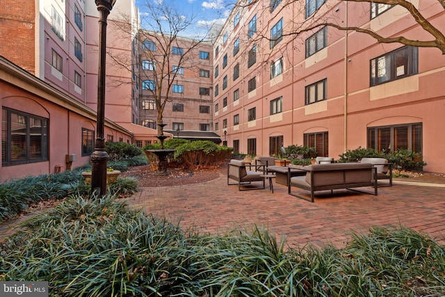 view of property's community featuring an outdoor hangout area and a patio