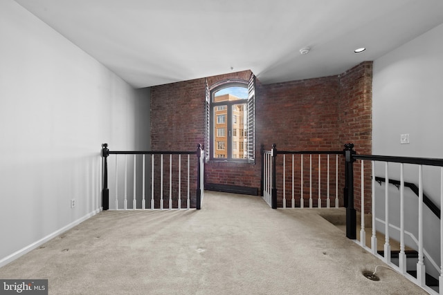 interior space with light carpet and brick wall