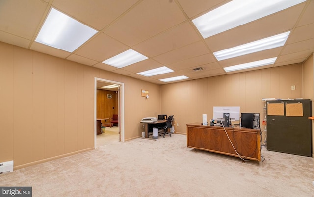 carpeted office with a paneled ceiling