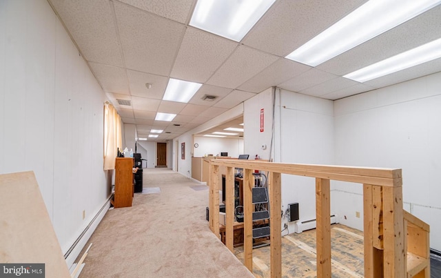 hall featuring carpet, a paneled ceiling, and baseboard heating