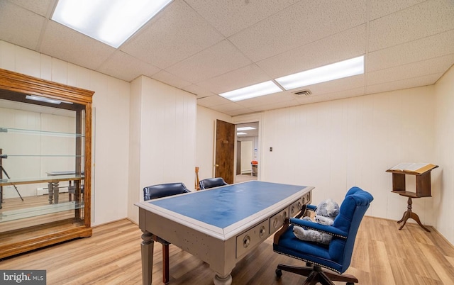 home office featuring a drop ceiling and light hardwood / wood-style flooring