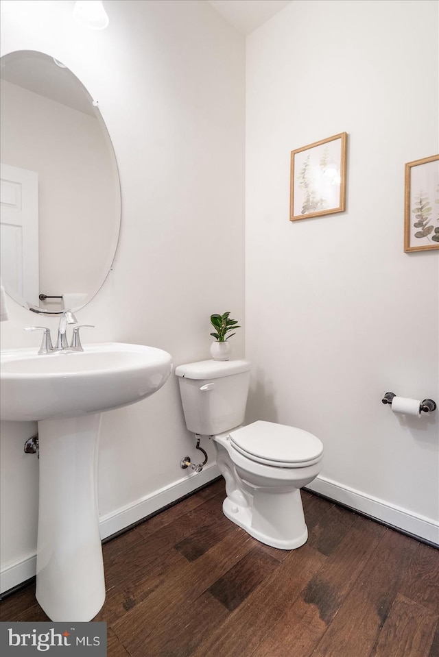 bathroom with hardwood / wood-style flooring and toilet