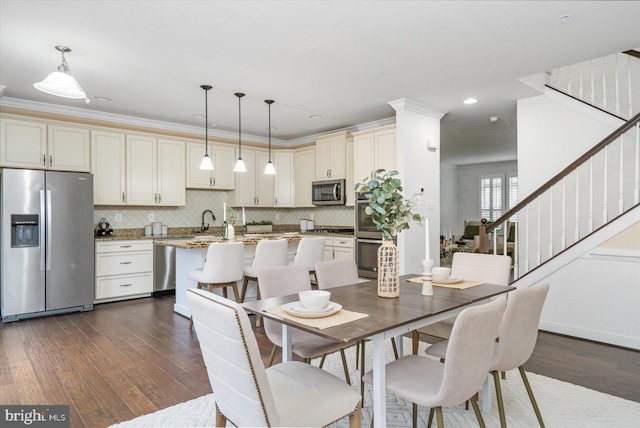 dining room with crown molding, sink, and dark wood-type flooring