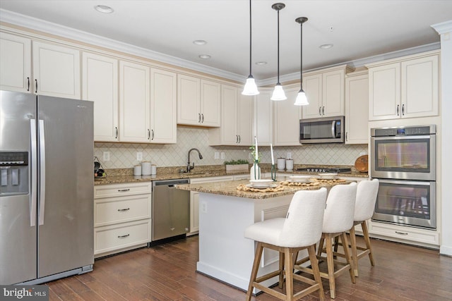 kitchen with dark wood-type flooring, stainless steel appliances, light stone counters, pendant lighting, and a kitchen island