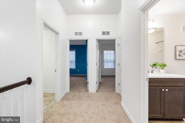 hall with light colored carpet