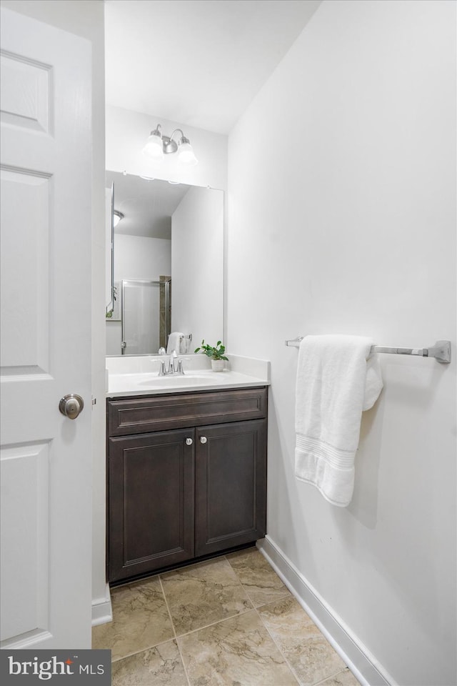 bathroom featuring vanity and a shower with door