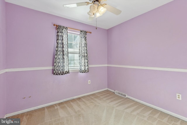 carpeted spare room featuring ceiling fan