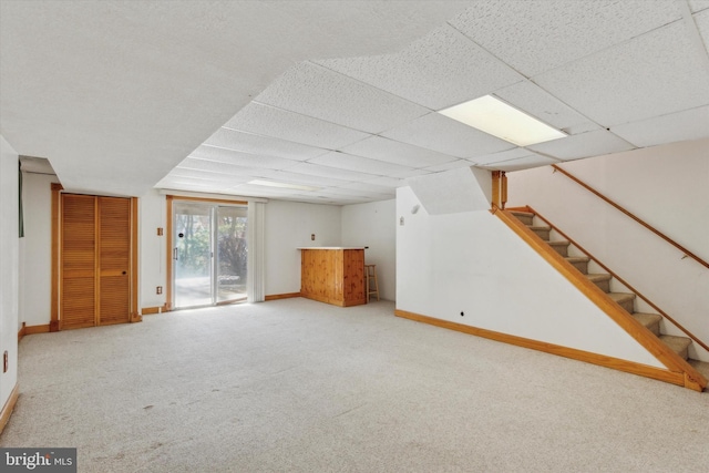 basement featuring carpet flooring and a paneled ceiling