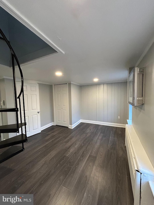 basement featuring ornamental molding and dark wood-type flooring