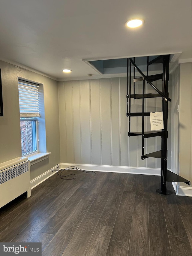 spare room featuring dark hardwood / wood-style flooring and radiator heating unit