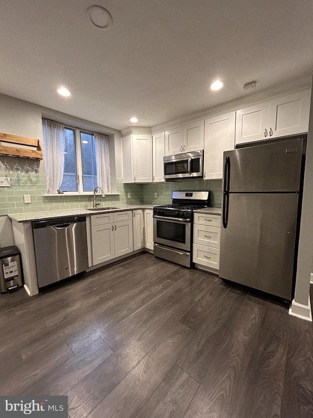 kitchen featuring white cabinets, sink, stainless steel appliances, and dark wood-type flooring