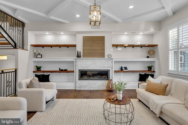 living room featuring hardwood / wood-style floors, beam ceiling, a wealth of natural light, and a fireplace