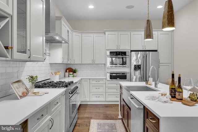 kitchen with wall chimney exhaust hood, appliances with stainless steel finishes, and white cabinets