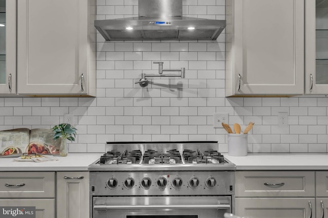 kitchen with tasteful backsplash, gas range, ventilation hood, and cooktop