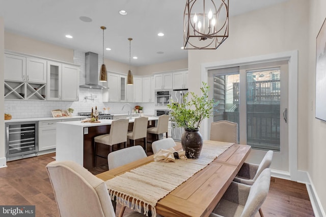 dining room featuring a notable chandelier, sink, wine cooler, and dark hardwood / wood-style flooring