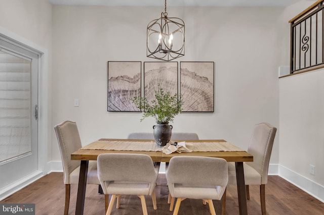 dining area with a notable chandelier and dark hardwood / wood-style floors