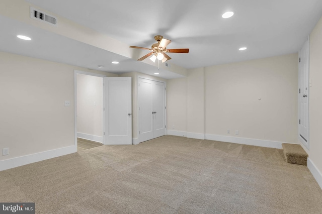 basement with light carpet and ceiling fan