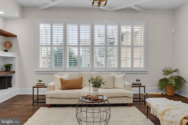 living area featuring beamed ceiling and dark hardwood / wood-style floors