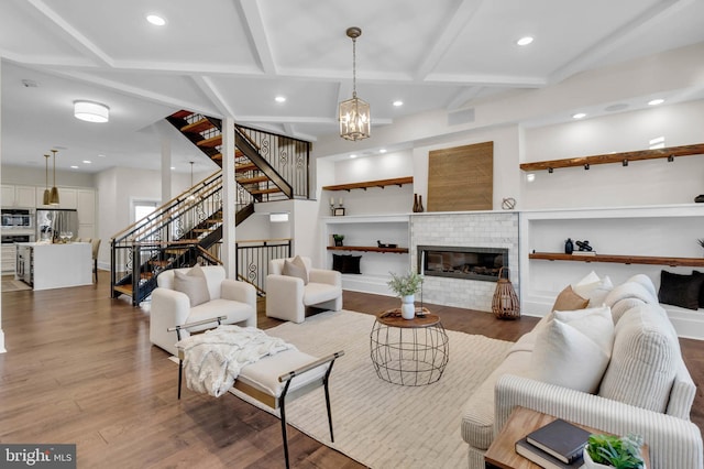 living room featuring hardwood / wood-style flooring, an inviting chandelier, and a fireplace