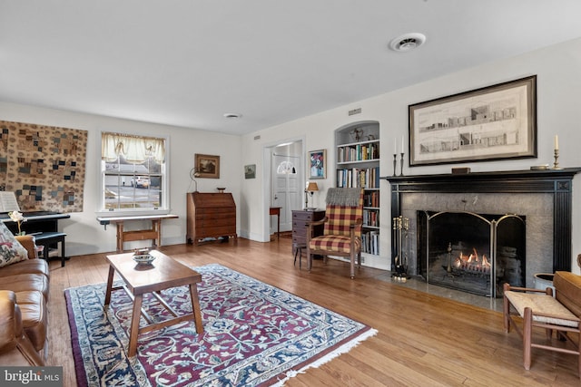 living room with wood-type flooring and built in features