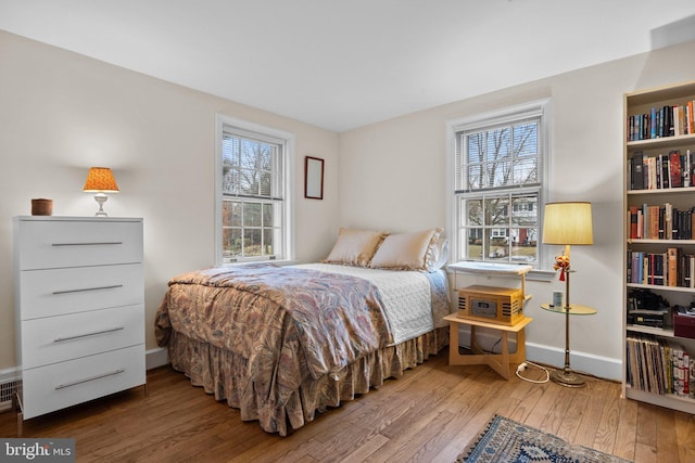 bedroom with hardwood / wood-style floors and multiple windows