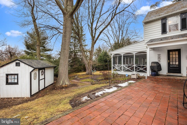 view of patio with a grill, a storage shed, and a sunroom