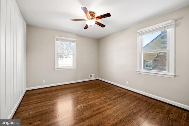 empty room with ceiling fan and dark wood-type flooring