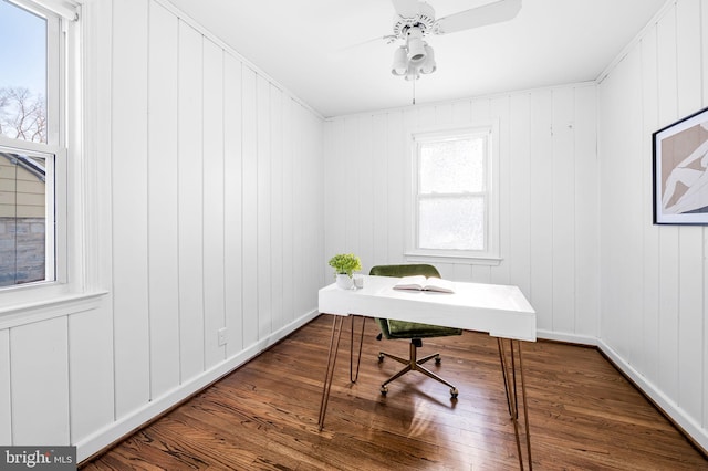 office space with ceiling fan, wood walls, and hardwood / wood-style flooring