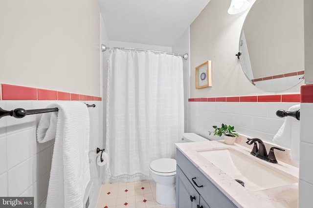 full bathroom featuring tile walls, toilet, vanity, and shower / tub combo