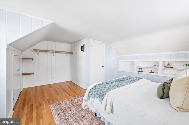 bedroom featuring light hardwood / wood-style floors and vaulted ceiling