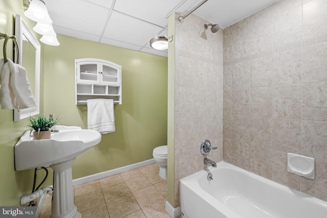 bathroom featuring toilet, tiled shower / bath, a drop ceiling, and tile patterned flooring