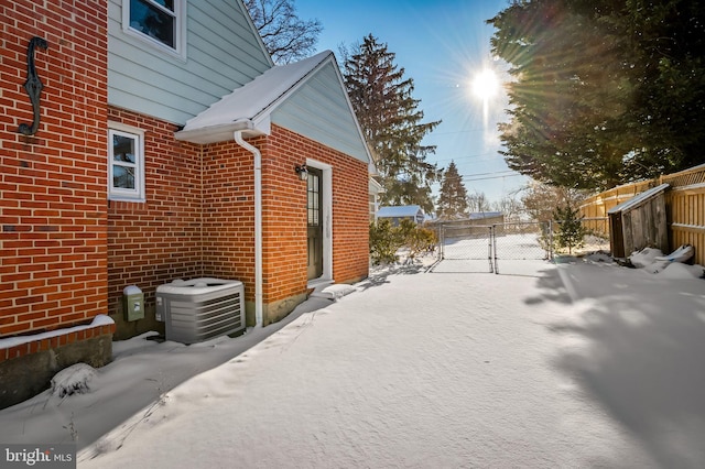 view of snow covered exterior featuring central AC unit