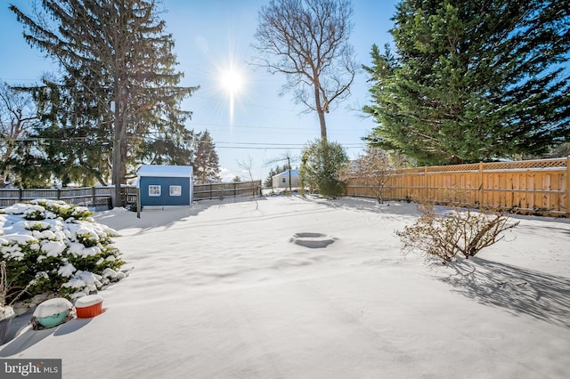 yard covered in snow featuring a storage unit