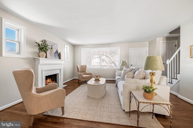 living room with a brick fireplace and hardwood / wood-style flooring