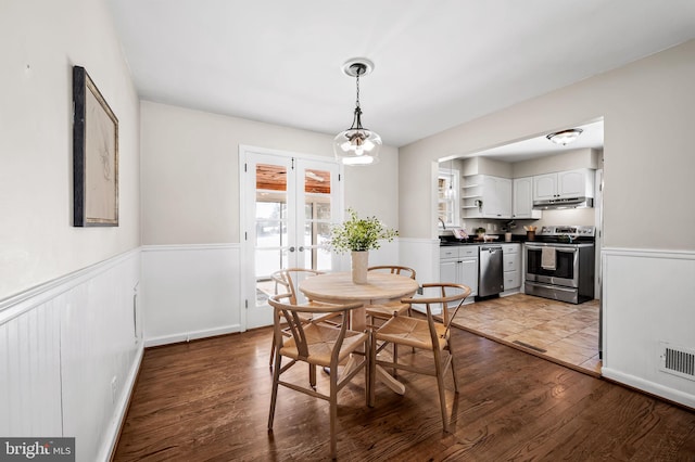 dining space featuring french doors, an inviting chandelier, and wood-type flooring