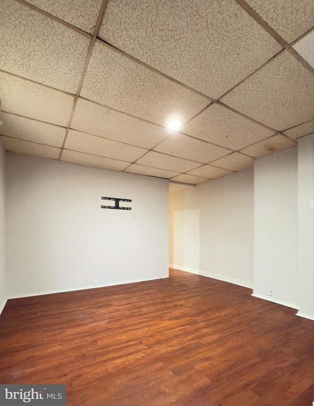 basement featuring a paneled ceiling and hardwood / wood-style flooring