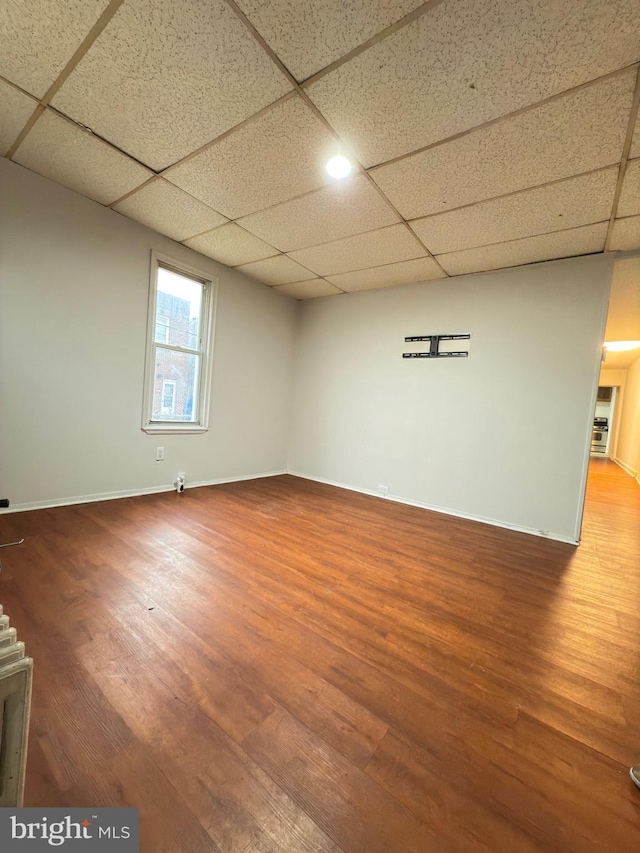 basement featuring hardwood / wood-style floors and a drop ceiling