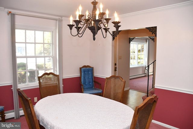 dining room featuring an inviting chandelier, a baseboard heating unit, and ornamental molding