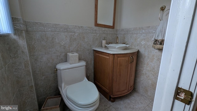 bathroom with vanity, tile walls, and toilet