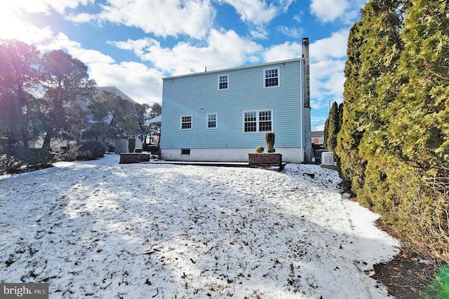 view of snow covered rear of property