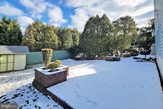 snowy yard with a shed