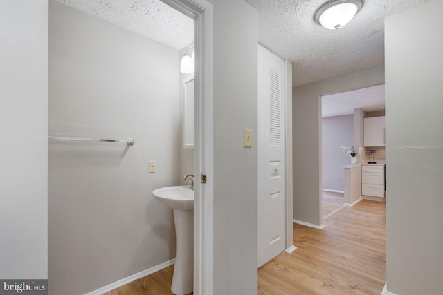 bathroom with hardwood / wood-style floors and a textured ceiling