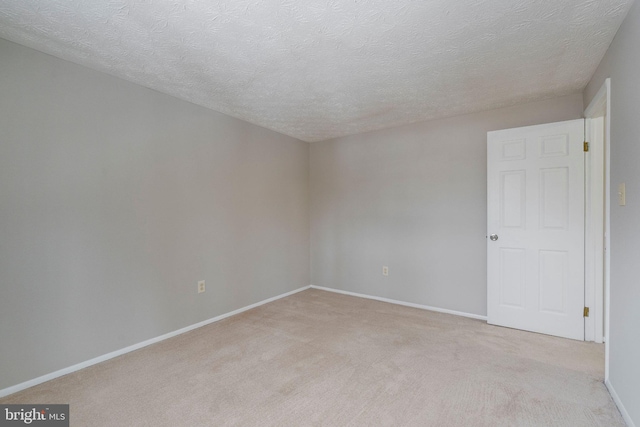 carpeted spare room with a textured ceiling