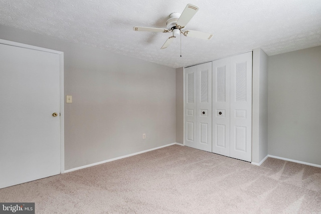 unfurnished bedroom featuring a textured ceiling, light colored carpet, and ceiling fan