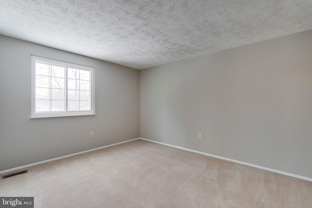 carpeted spare room with a textured ceiling