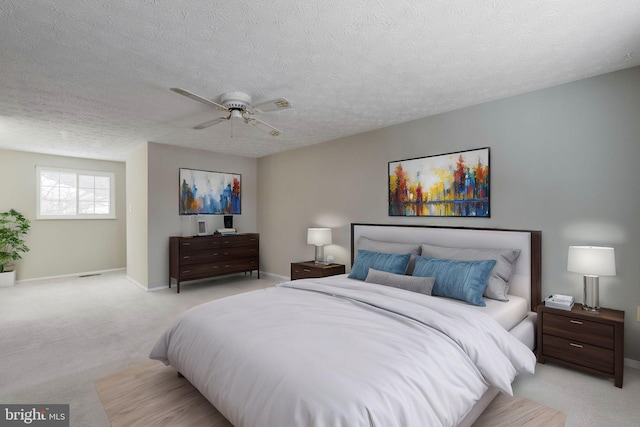 carpeted bedroom featuring a textured ceiling and ceiling fan